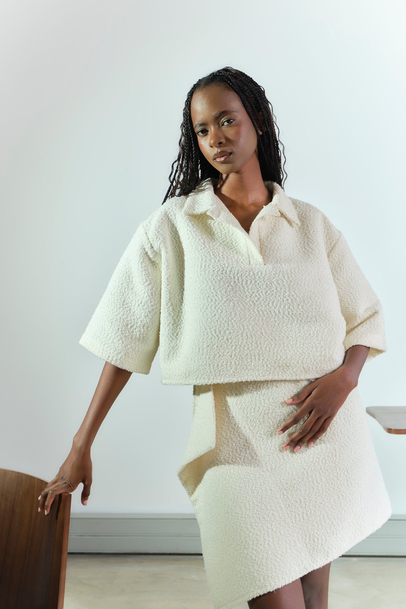 Woman wearing a white textured outfit against a plain background