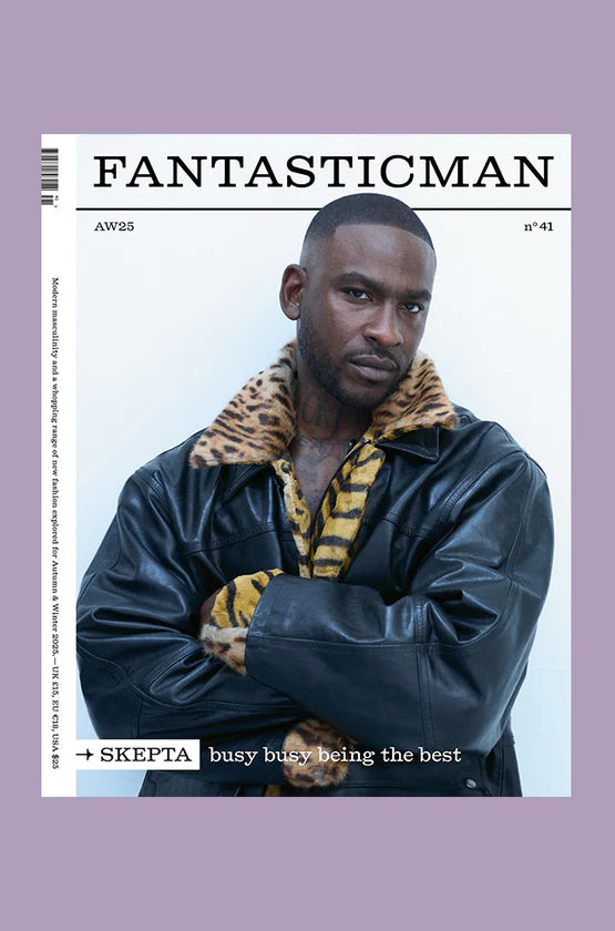 Magazine cover featuring a person wearing a leather jacket with a fur-lined hood, on a light purple background.