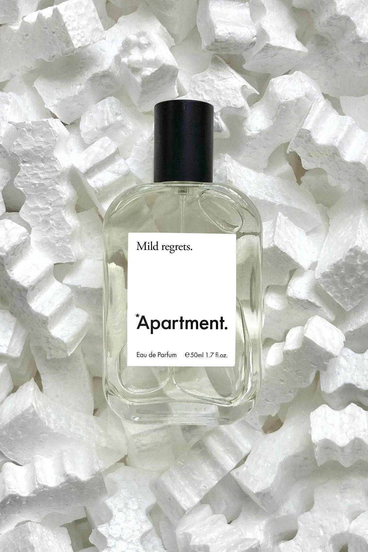 Perfume bottle labeled 'Apartment' on a white textured background